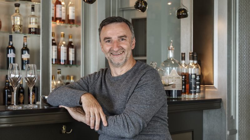 Porträt eines lächelnden Mannes an der Bar.