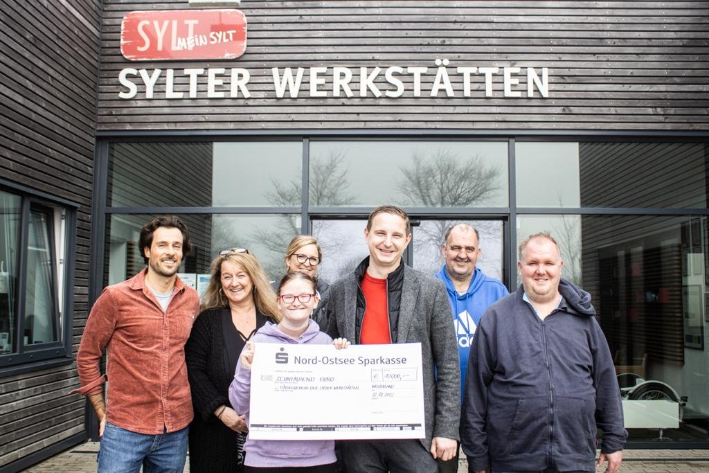 Jan-Philipp Berner überreicht einen Scheck über 10.000 Euro Sylter Werkstätten