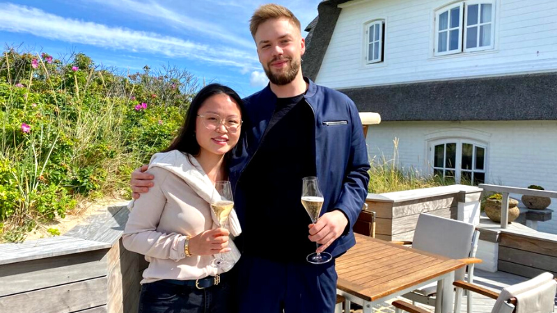 Zwei Personen mit Getränken auf der Terrasse.