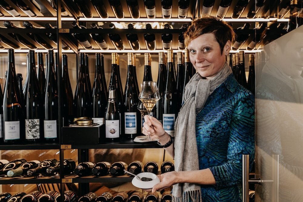 Bärbel Ring steht mit einem Glas Champagner in der Hand vor dem neuen Weinkeller im Söl'ring Hof.