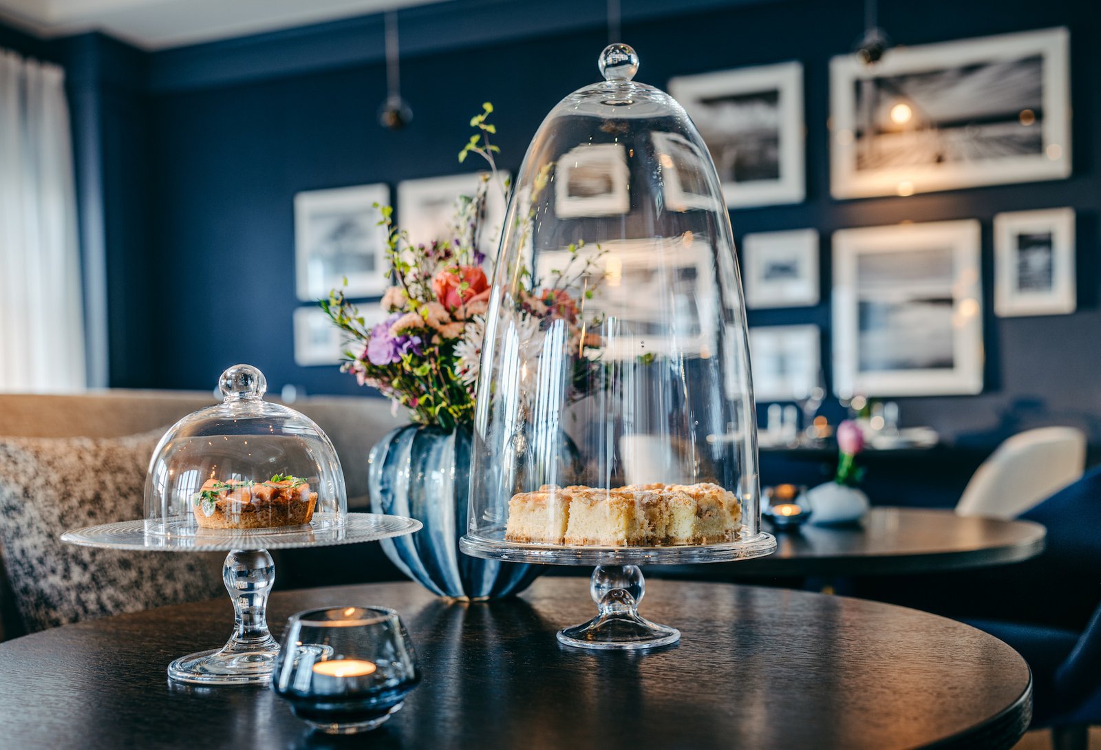 Nachmittage im Wohnzimmer. Kuchen auf Glasteller mit Glasglocke.