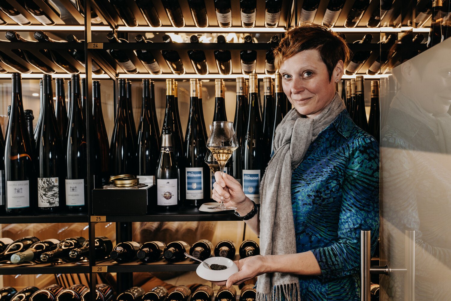 Bärbel Ring steht mit einem Glas Champagner in der Hand vor dem neuen Weinkeller im Söl'ring Hof.