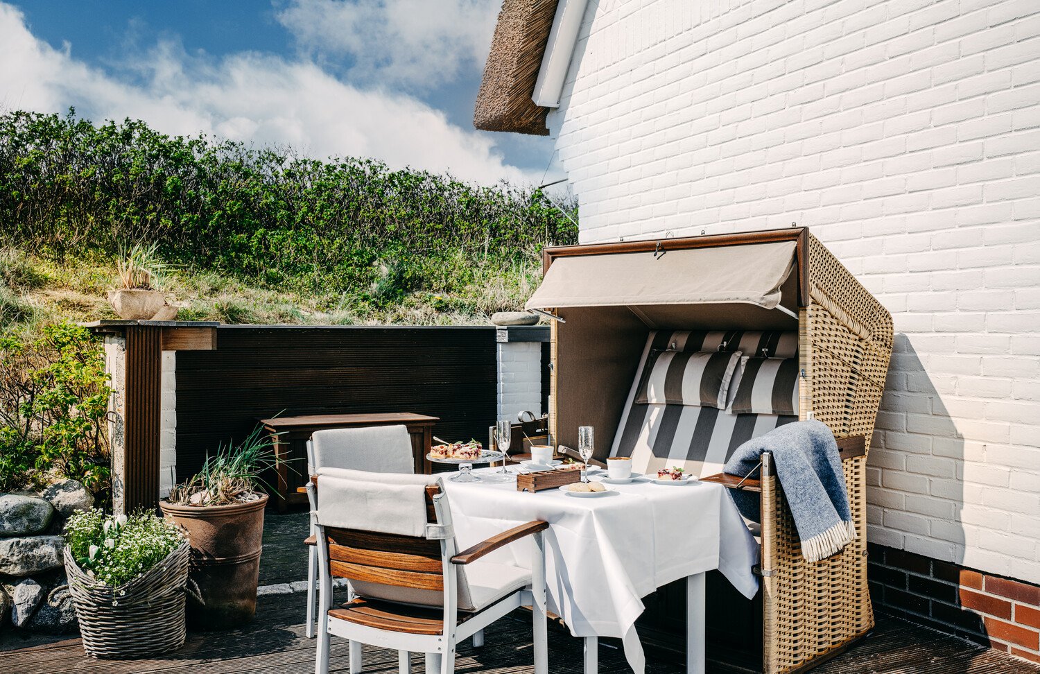 Ein Strandkorb auf der Terrasse eines Doppelzimmers bei Sommer.