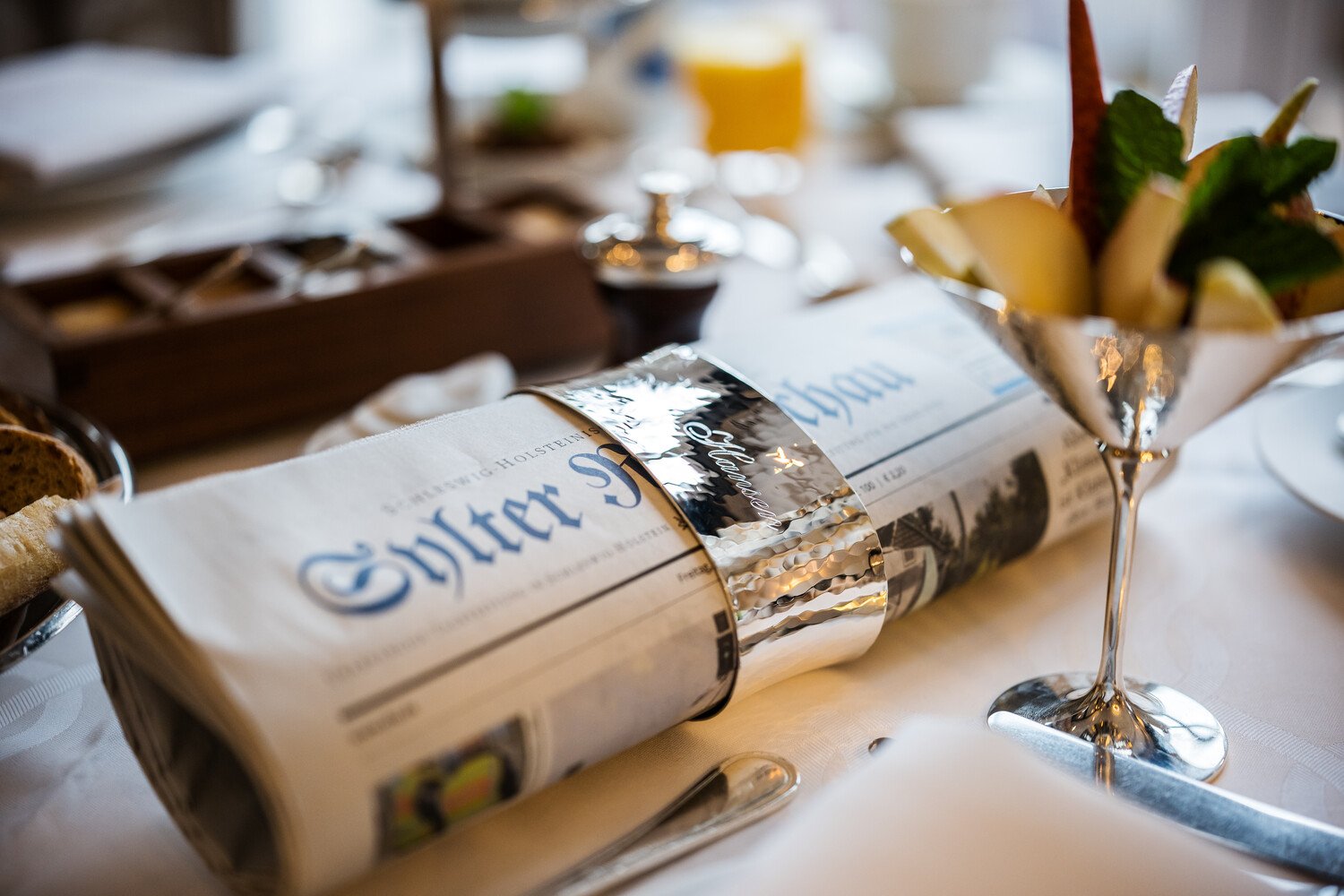 Breakfast, newspaper, and fruit at Söl’ring Hof, Sylt holiday destination.