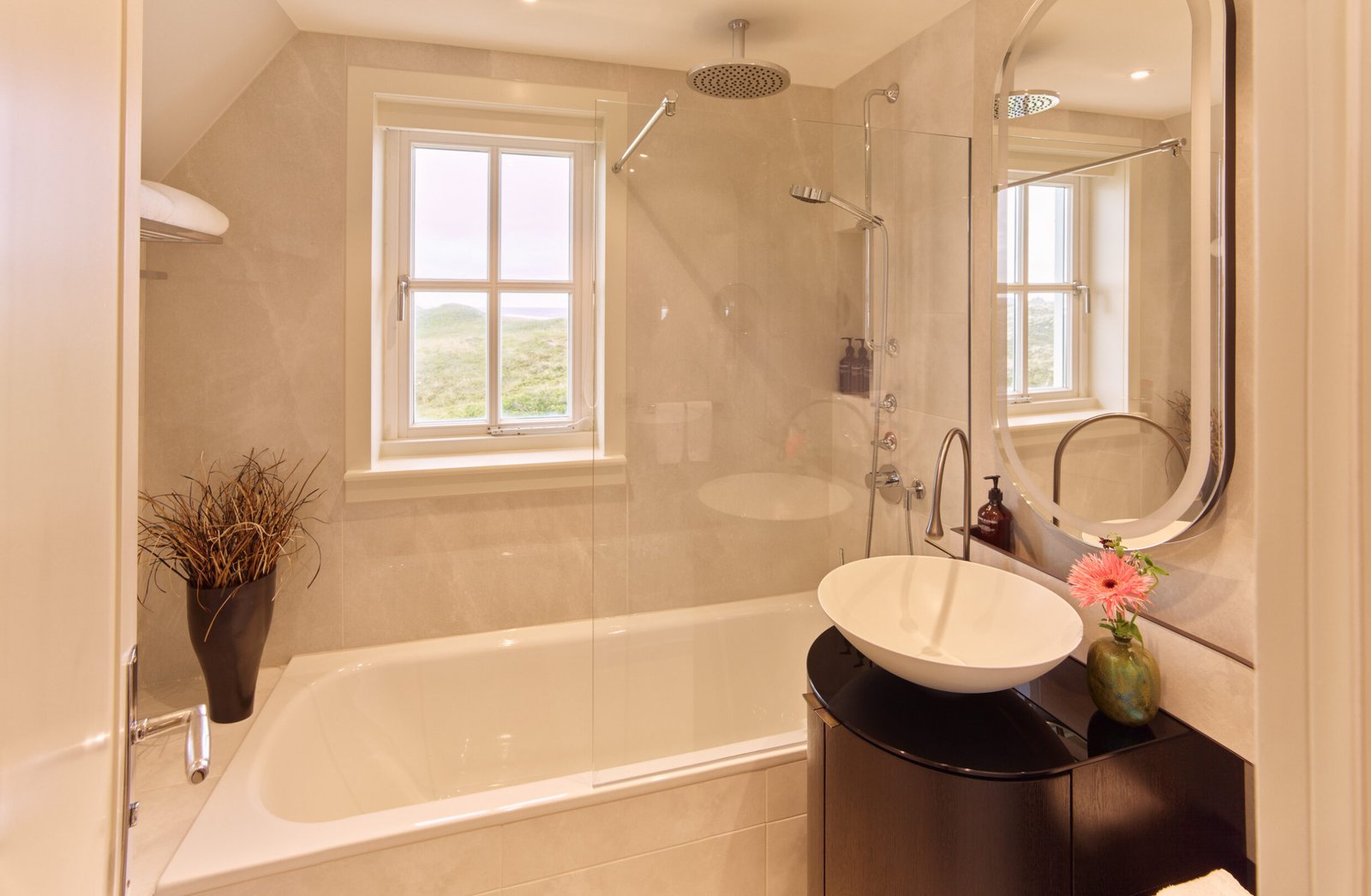 Elegantes Badezimmer im Söl’ring Hof auf Sylt mit malerischem Blick auf die Küste.