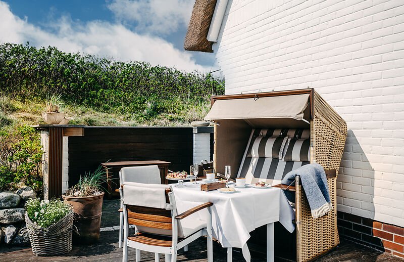 Frühstücksterrasse im Söl’ring Hof, Sylt; ein üppiger, einladender Urlaub.
