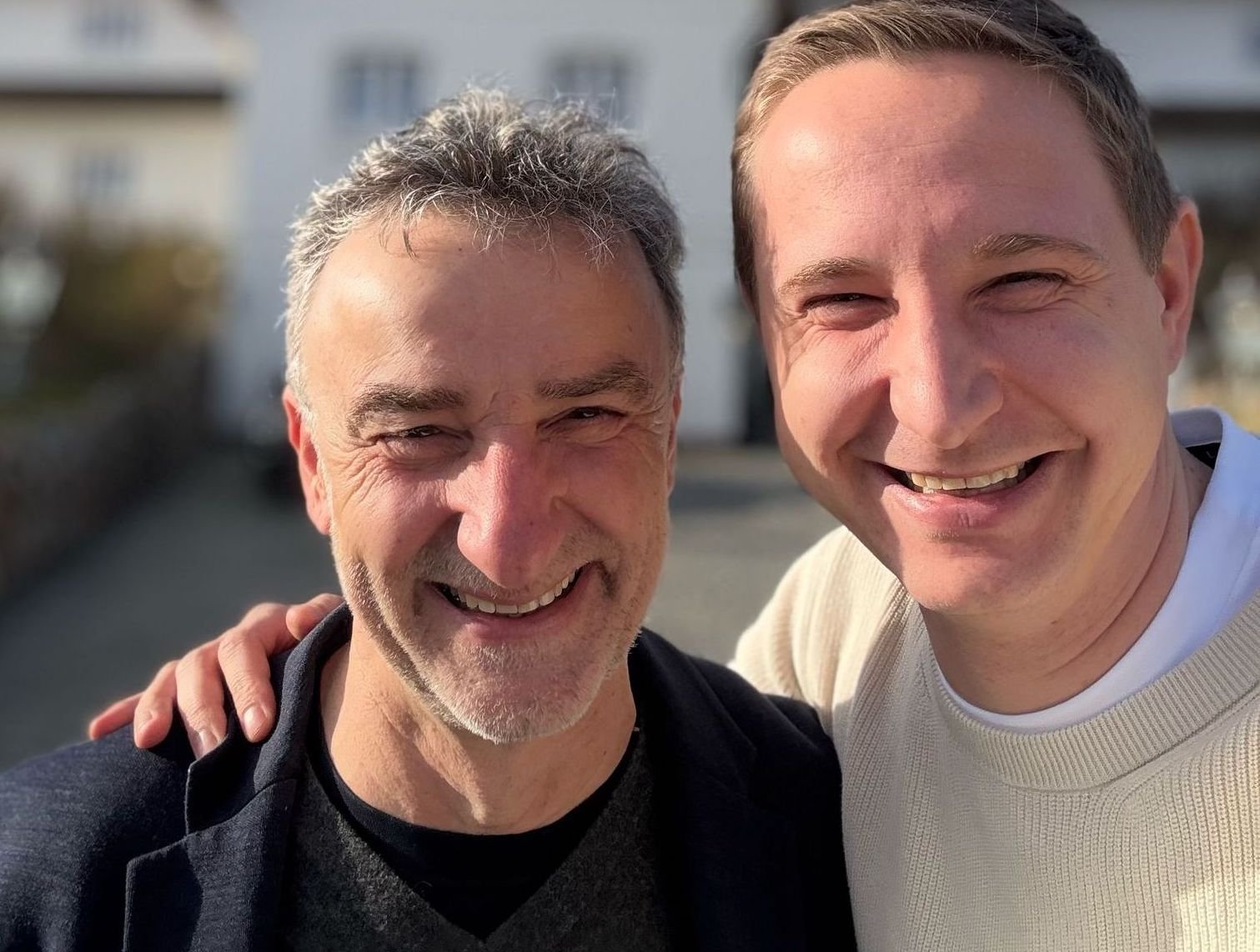 Zwei lächelnde Männer am Söl’ring Hof, einem Urlaubsziel auf Sylt.