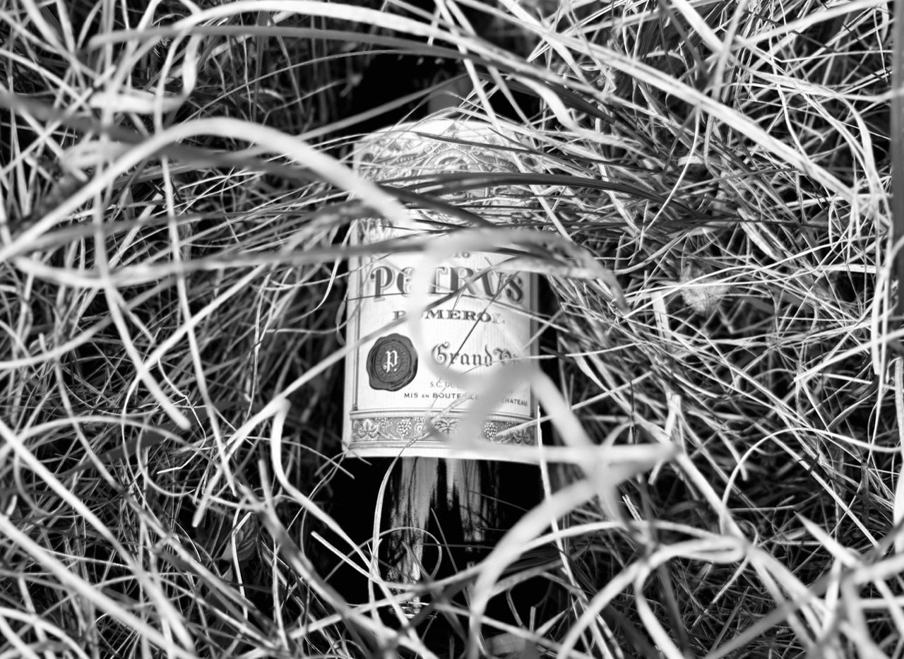 Schwarz-weiße Petrus Grand-Flasche im Gras, Söl’ring Hof Sylt.