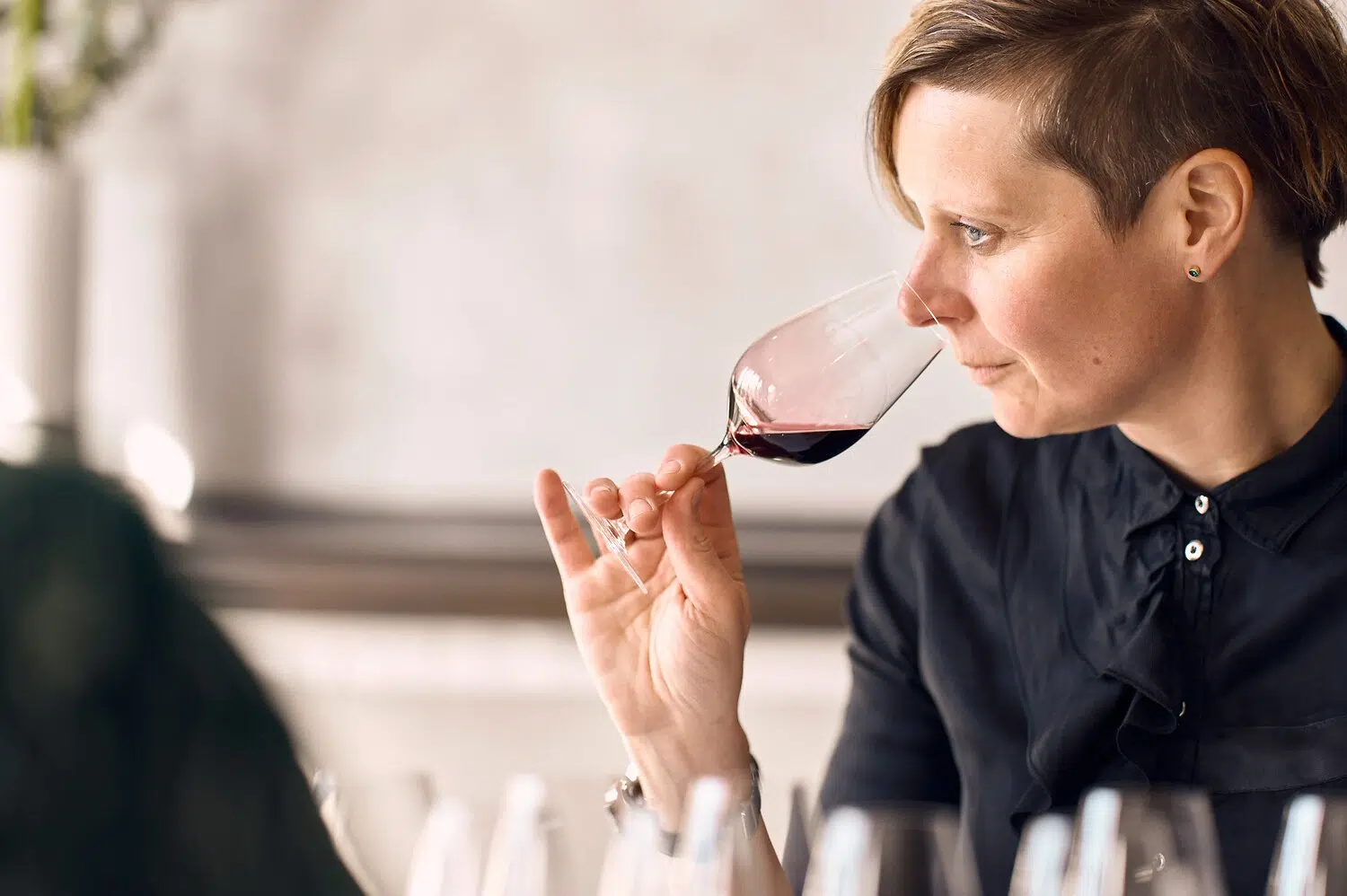 Eine Frau riecht an Rotwein im Söl’ring Hof, einem Urlaubsziel auf Sylt.
