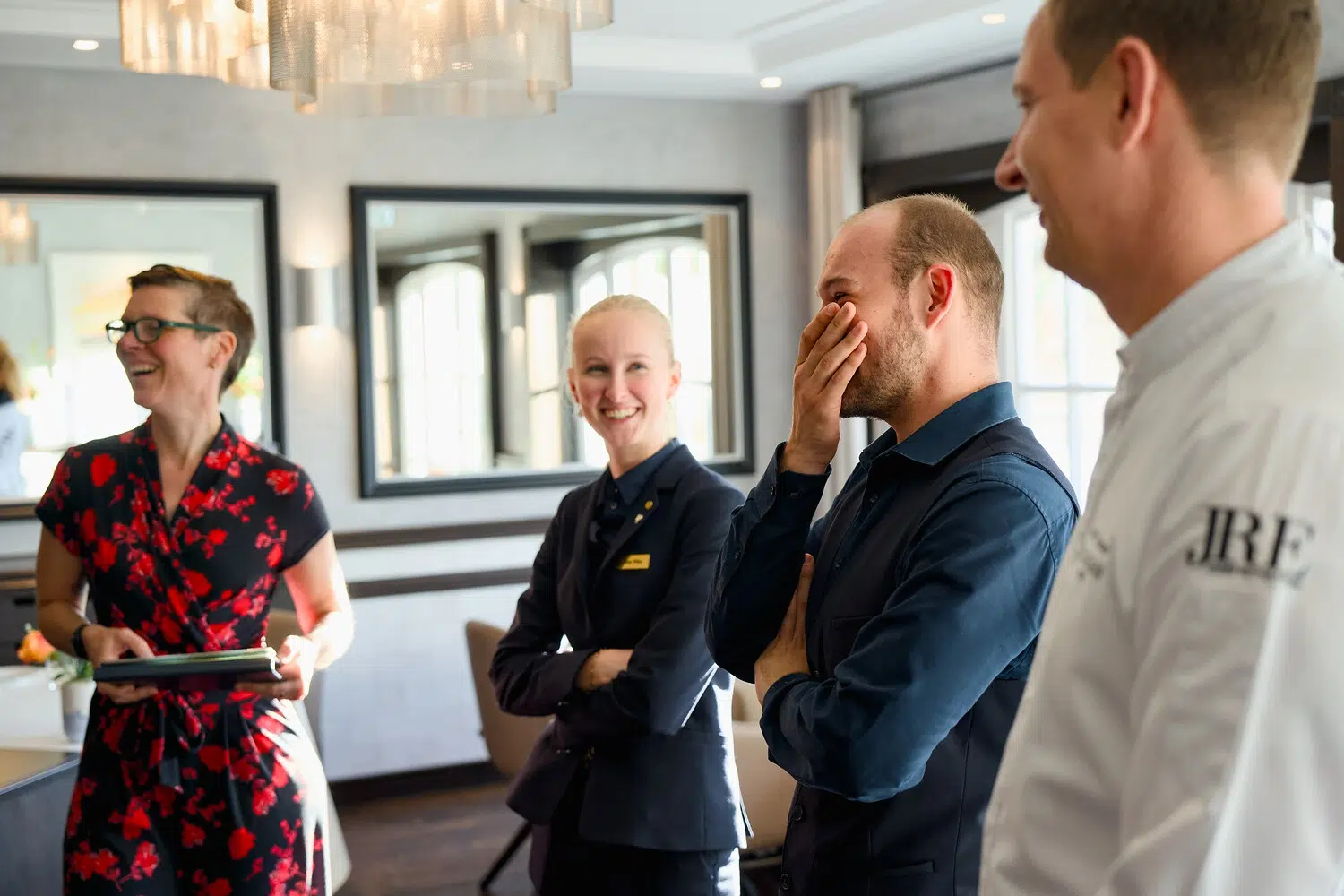 Mitarbeiter lachen gemeinsam im Ferienresort Söl’ring Hof auf Sylt.